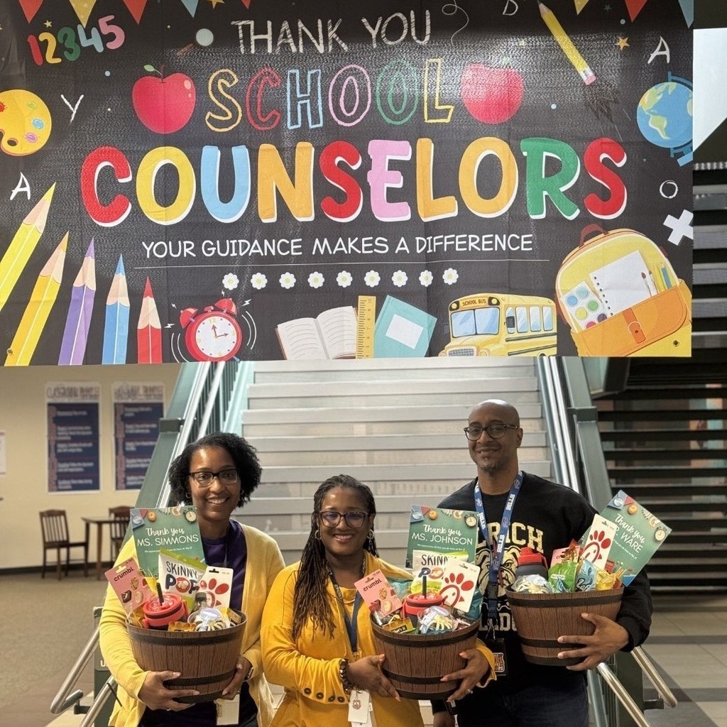 Ulrich counselors in front of celebration banner.