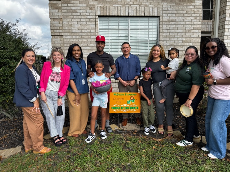 Group of people gathered with a yard sign. 