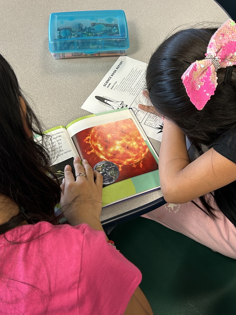 students reading a book and drawing their learning