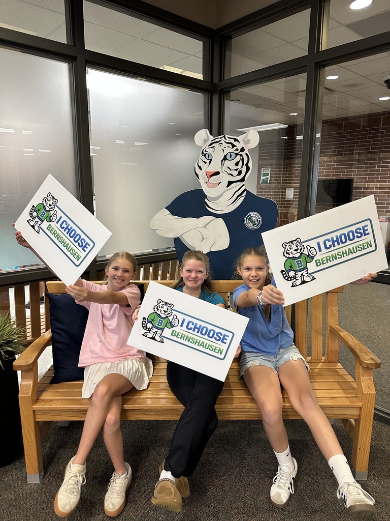 3 student council members showing off our new signs