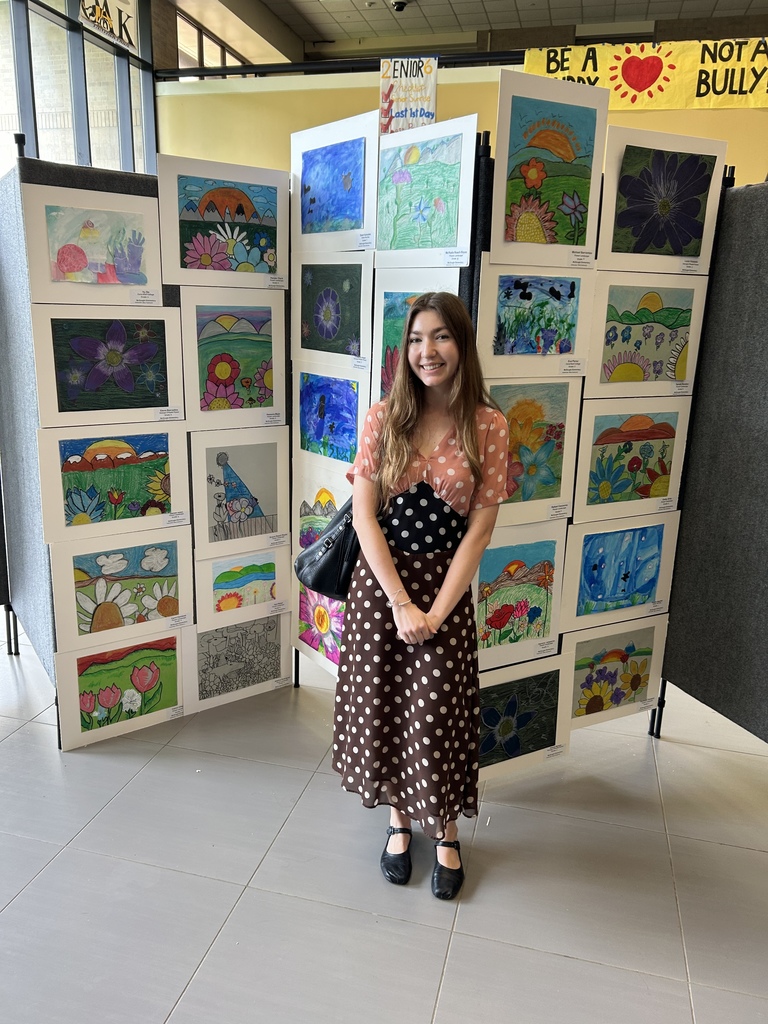 Art teacher displaying student work.