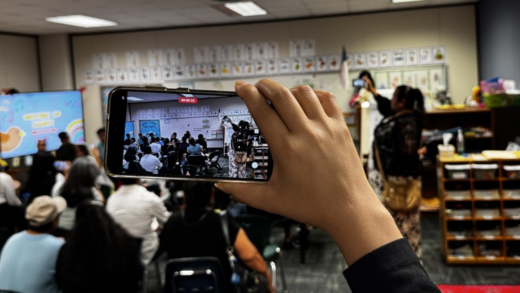 Parent capturing a moment through their phone. 