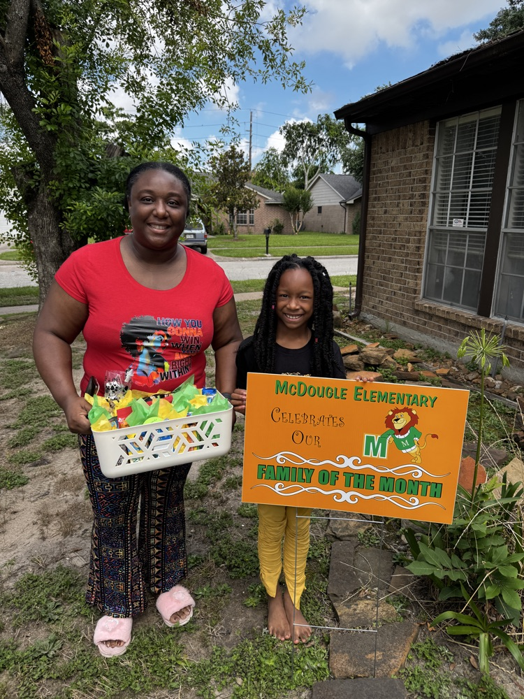 Mom and daughter with yard sign for family of the month. 