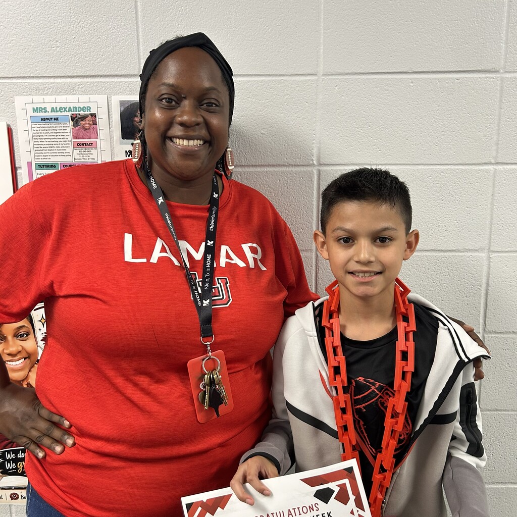 Woman and child smiling, standing next to each other. Woman wearing a red Lamar shirt. Child holding a certificate.