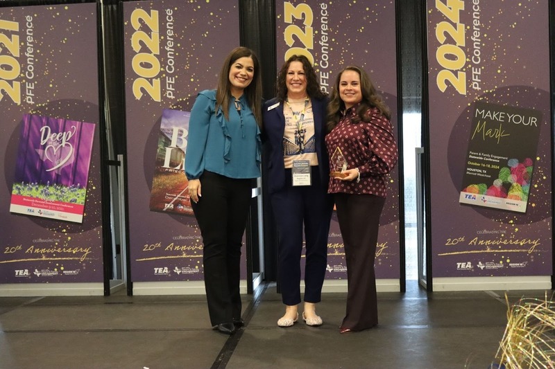 three women smiling with award