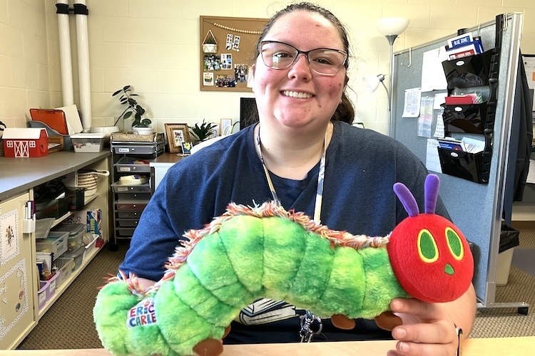 Sarah Hill uses a stuffed caterpillar toy to help her preschoolers understand prepositions such as over, under and around