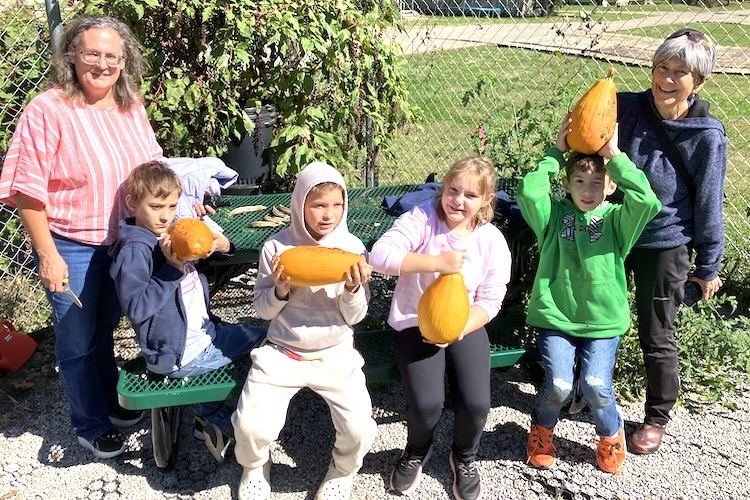 While their classmates explored the Arch Park Community Garden these Learning Center elementary students displayed the gourds they grew from seeds. Joining the children are teacher Angela Arbogast, left, and Erin Salva, community garden coordinator