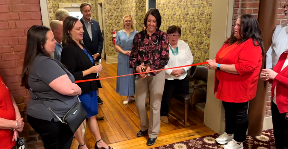 Office Manager Carla Douglas cuts a Knox Chamber of Commerce ribbon that officially welcomed the Knox Educational Service Center to its new office on the second floor of the Woodward Annex, 107 S. Main St. 