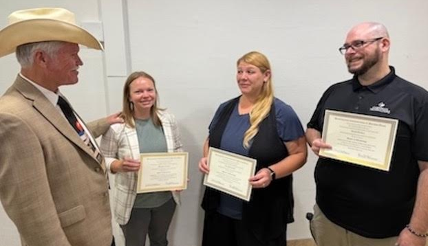 Superintendent Dr. Timm Mackley congratulates Doctor of Thinkology recipients, from left, ESC Treasurer Melissa Carpenter, Learning Center art teacher Kim Aritonovich and district IT manager Jared Tarbert