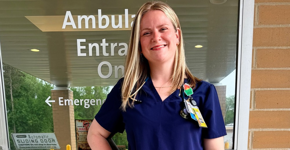 Brandie Keller standing in scrubs in from of ER door