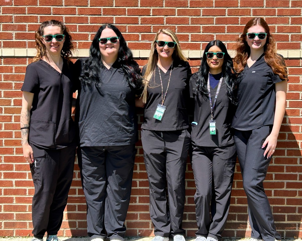Group of 5 Nail Technician students standing together outside again a wall with sunglasses on