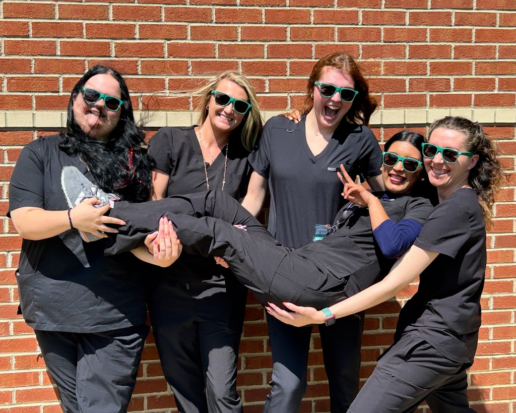 Group of 5 Nail Technician students standing together outside acting silly with sunglasses on