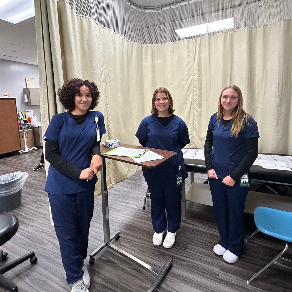Three MA students standing in the lab, smiling