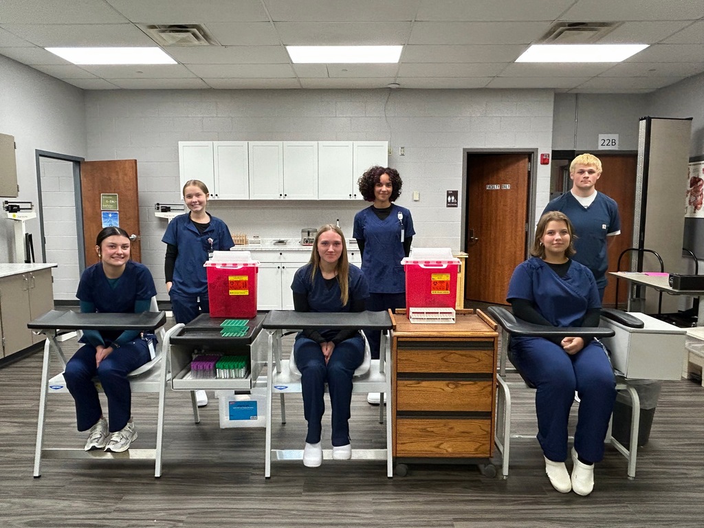 6 Medical Assistant students in the lab, around te medical equipment
