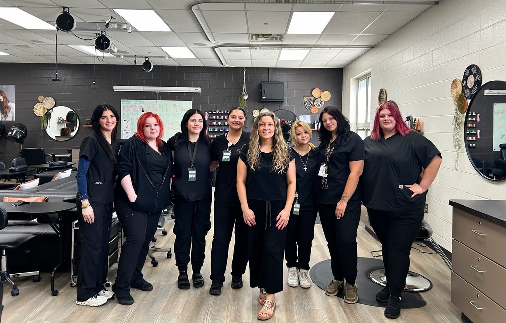 7 Cosmetology students standing in lab with Wella Instructor