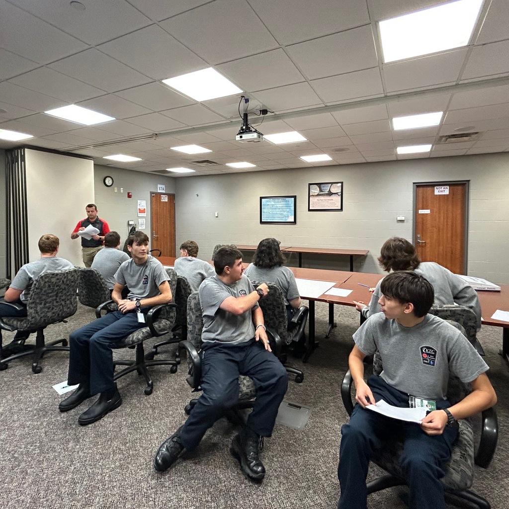 a class of 8 public safety students sitting on chairs back to back