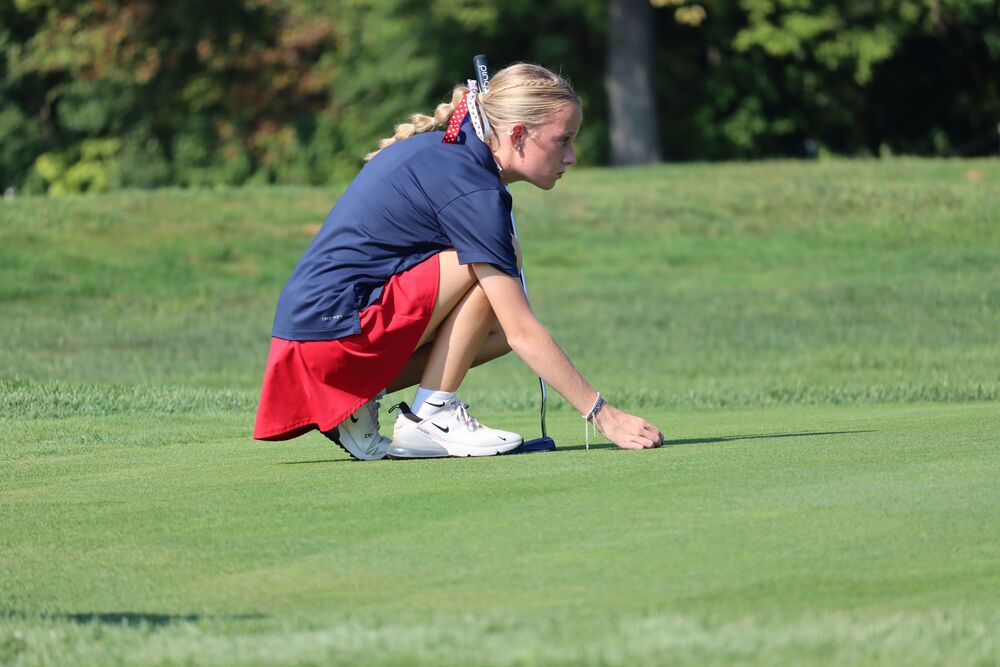 Sophomore Kate Anthony lines her ball up on the green. Anthony and the LadyKat golfers compete in the IHSAA regional today.