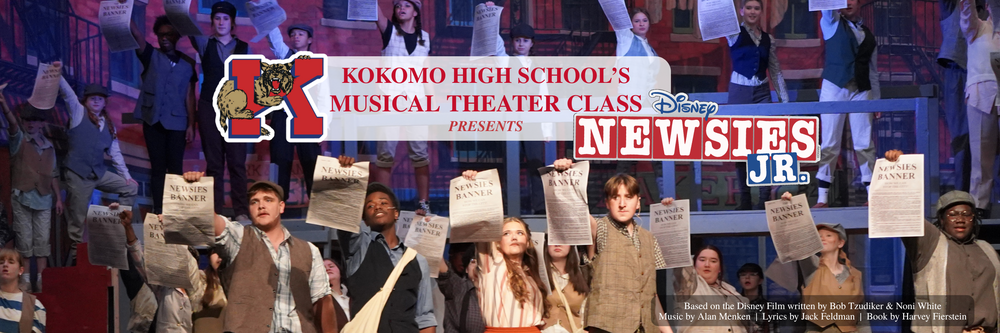 students on stage holding newspaper front page