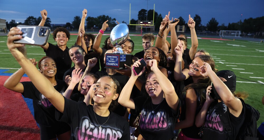 group of female flag football players holding trophy