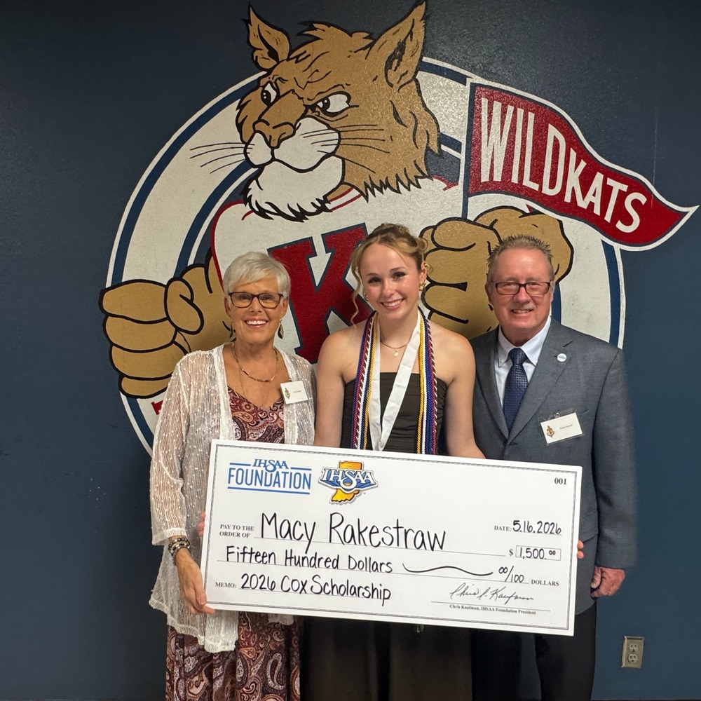 man and woman standing with high school senior girl who is holding a scholarship check