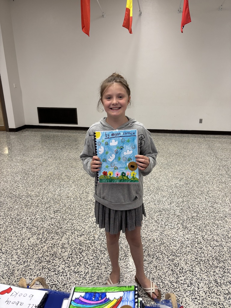 One of our young authors proudly displaying her work!