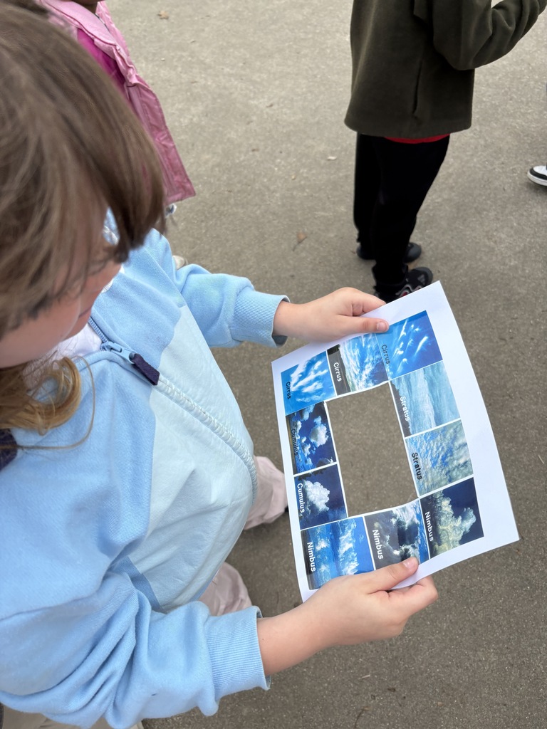 A student studies the cloud identifier paper to learn about different cloud formations.