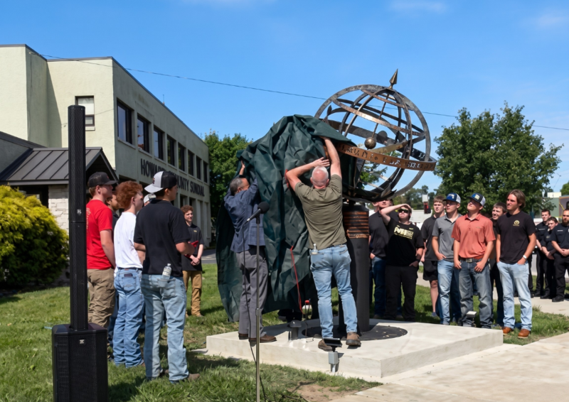 removing tarp from globe sculpture