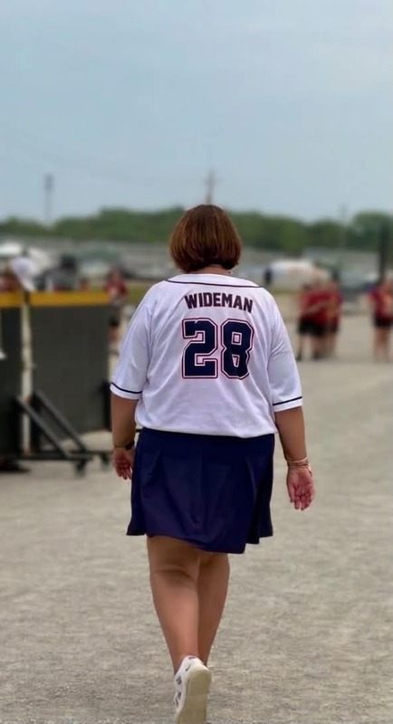 woman wearing wideman in baseball jersey walking away