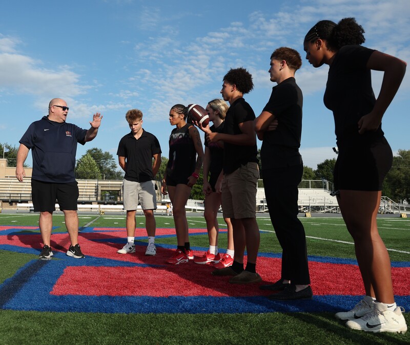 student athletes on a football field learning to coach