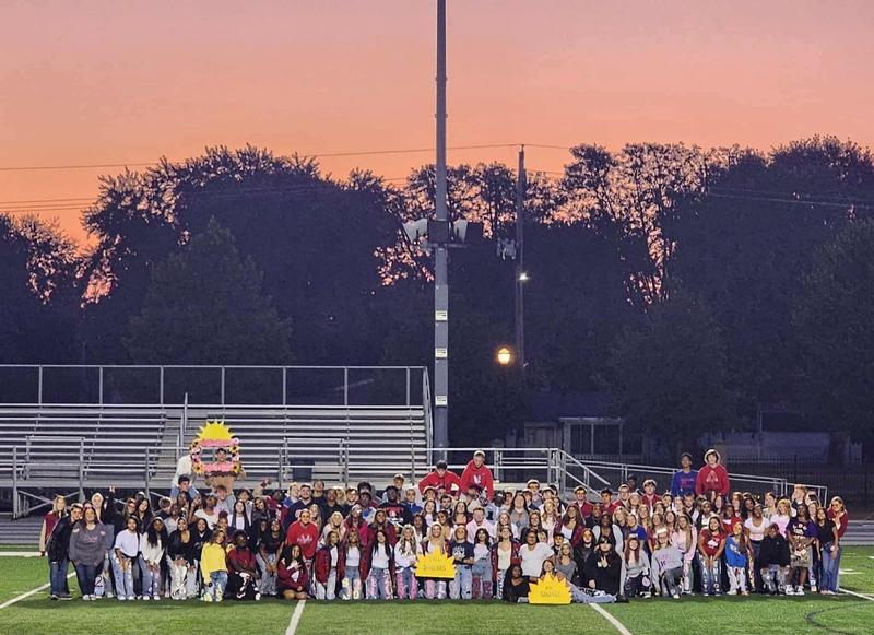 student on football field at sunrise