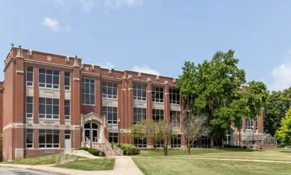 brick school building blue sky greenery