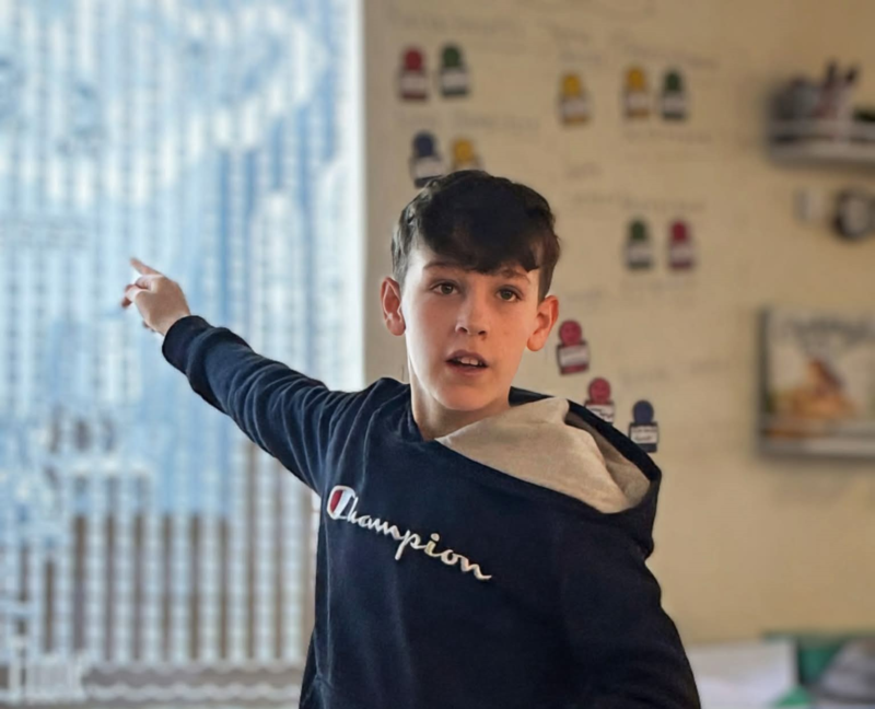 boy pointing to white board