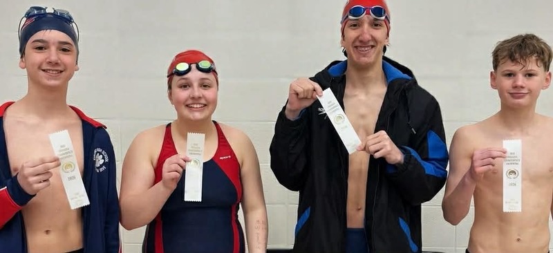 4 swimmers holding ribbons
