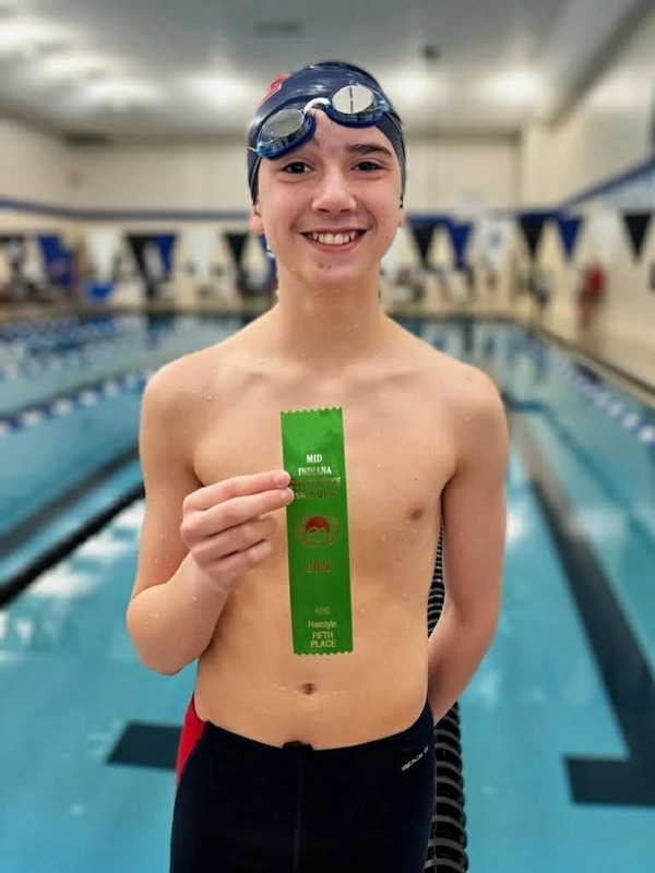 boy swimmer holding ribbon