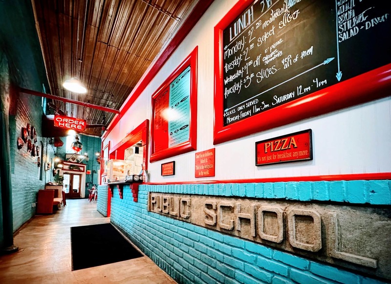 pizza shop entrance with text in stone "public school"