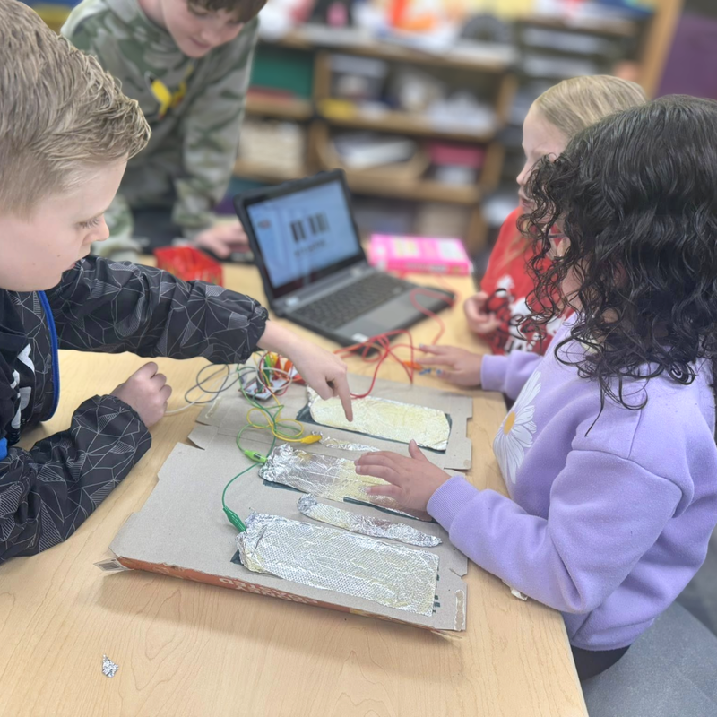 elementary student children working with circuits on a laptop