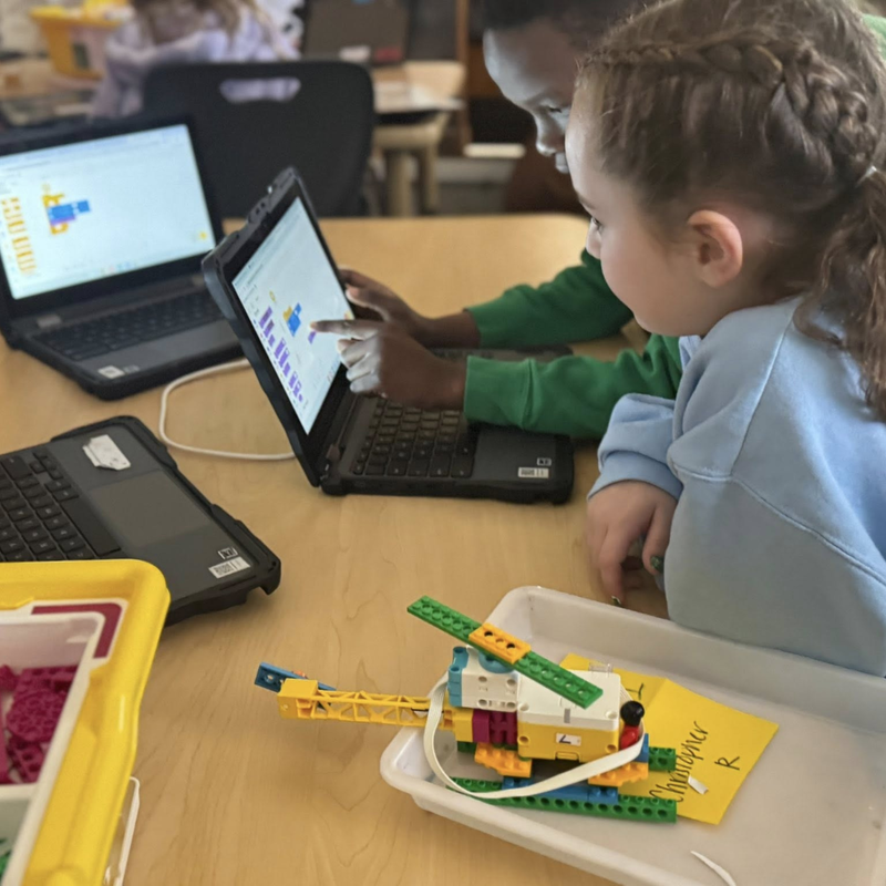 kids coding on laptop and working with legos