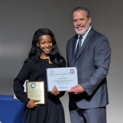 girl holding certificate from city official