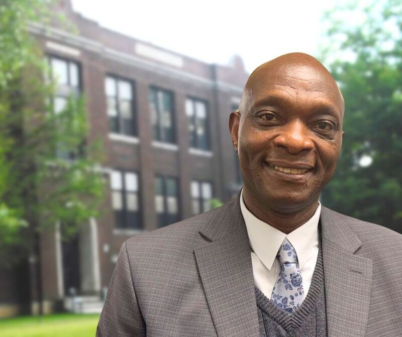 man standing in front of brick school building