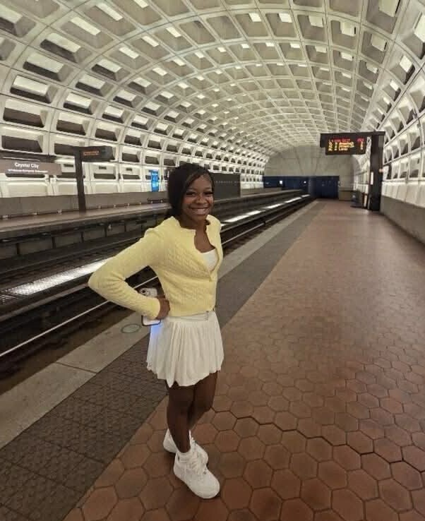 girl smiling standing with hand on hip in train station