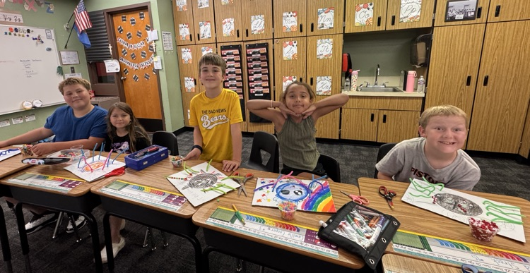 Students smiling while working on crafts.