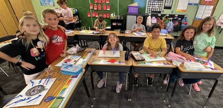 Students smiling while working on crafts.