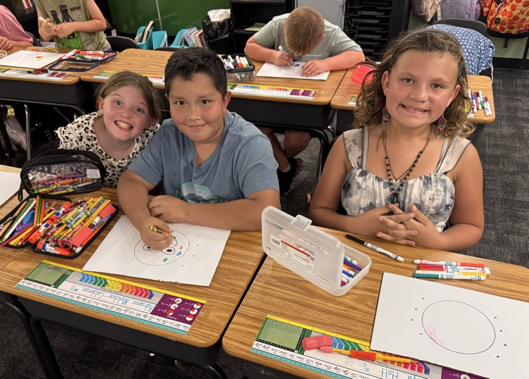 Students smiling while working on crafts.