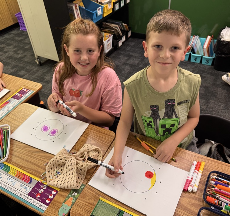 Students smiling while working on crafts.