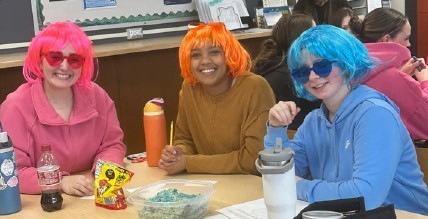 THree LHS students participating in the Academic Bowl with wigs and sunglasses