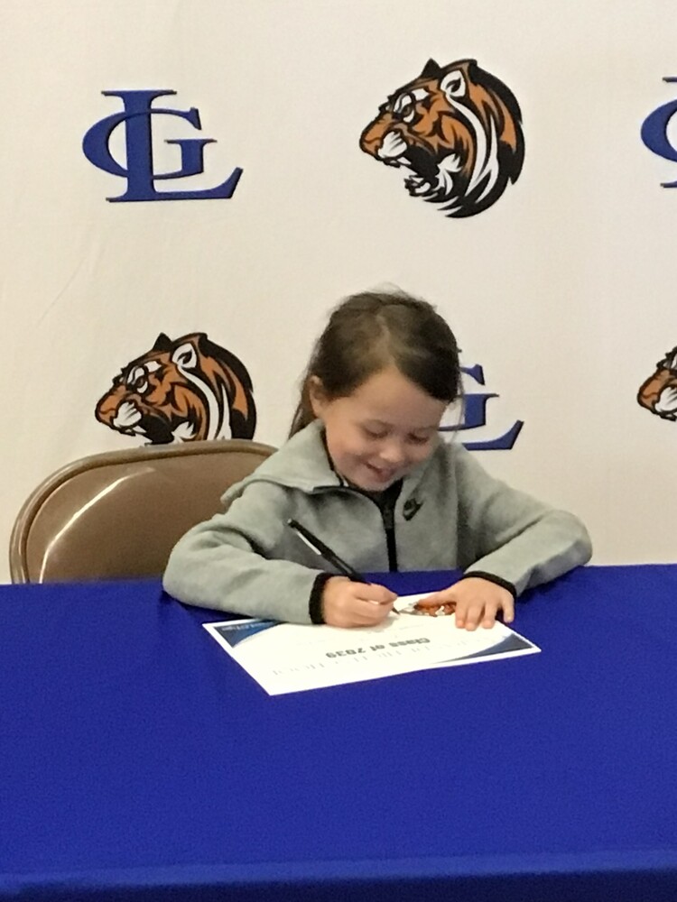 PHoto of a La Grande Tiger kindergarten student signing on to be a La Grande TIger!