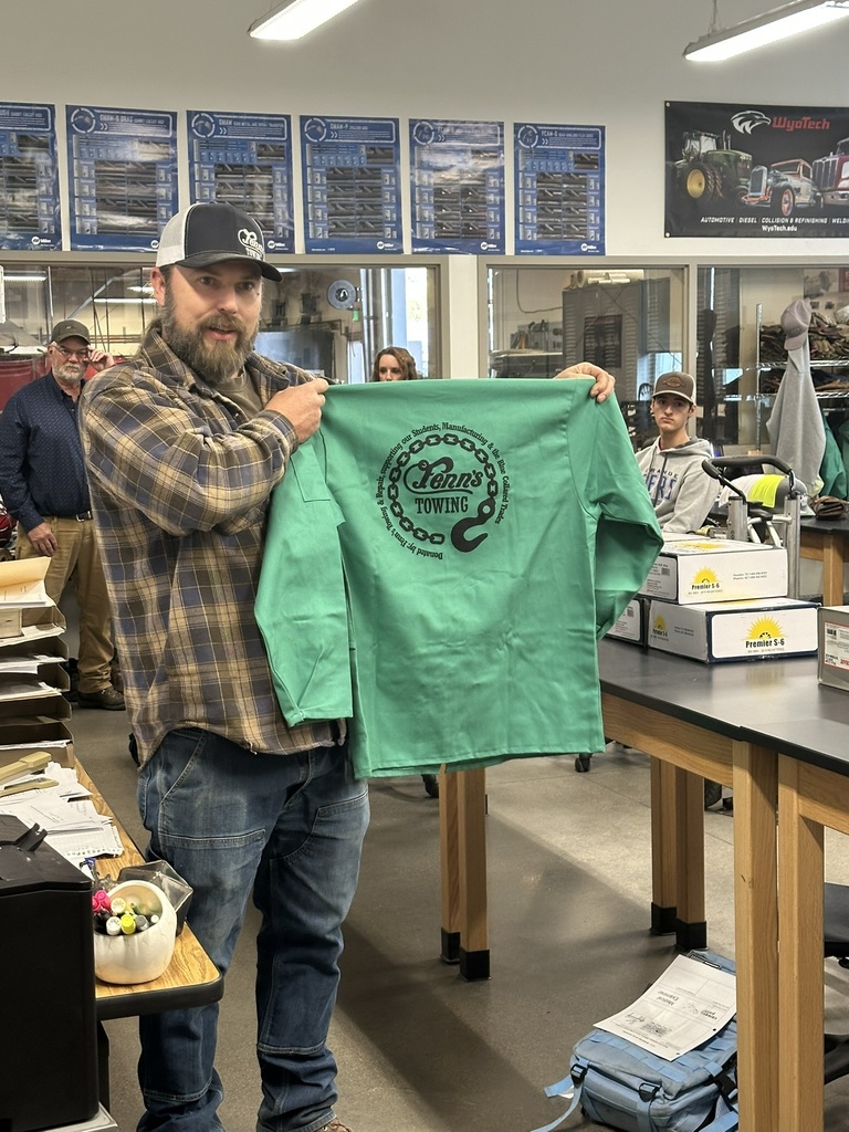 Mr Gisi holding up a new welding jacket featuring the Fenn's Towing logo