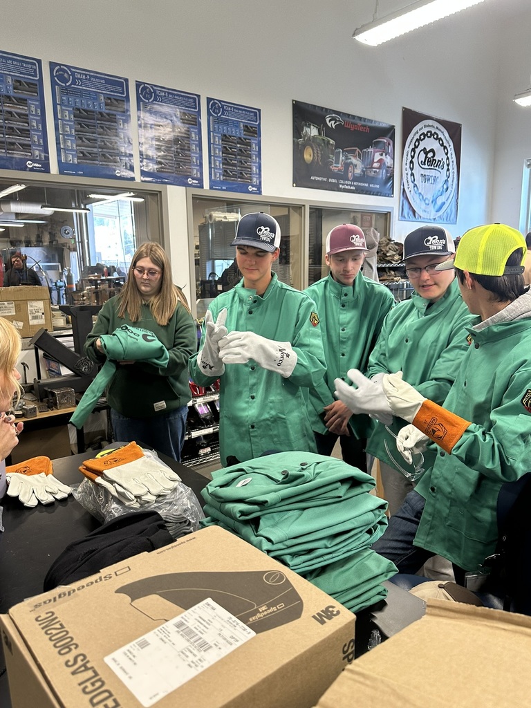 students trying on the new welding equipment donated by Fenn's Towing