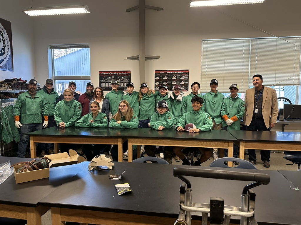 Mr Gisi, his welding students, the owners of Fenn's Towing and superintendent Mendoza with students wearing new welding jackets