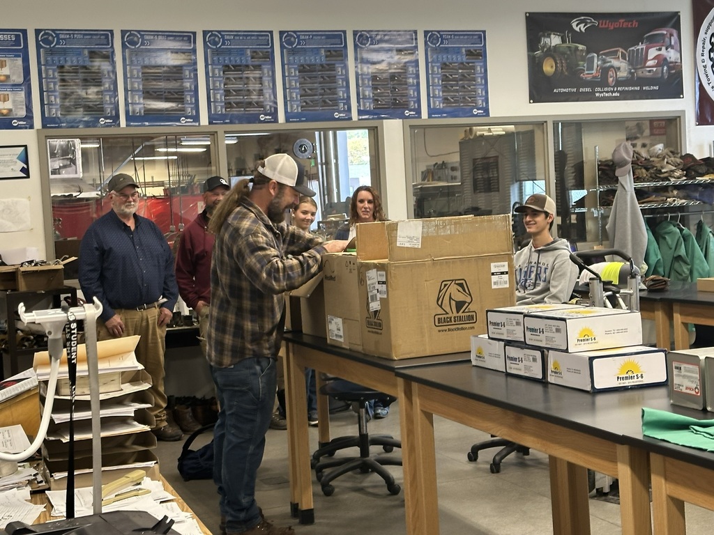 Mr Gisi opening up the donated items with Fenns Towing owners and students watching